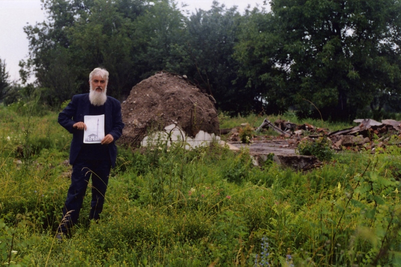x5. Imam Osman ef. Mulahuseinović at the remains of the completely demolished mosque at Modrička Lug in June 2001 with a photograph of the structure before its destruction. © Richard Carlton 